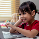 Kid working on laptop happily