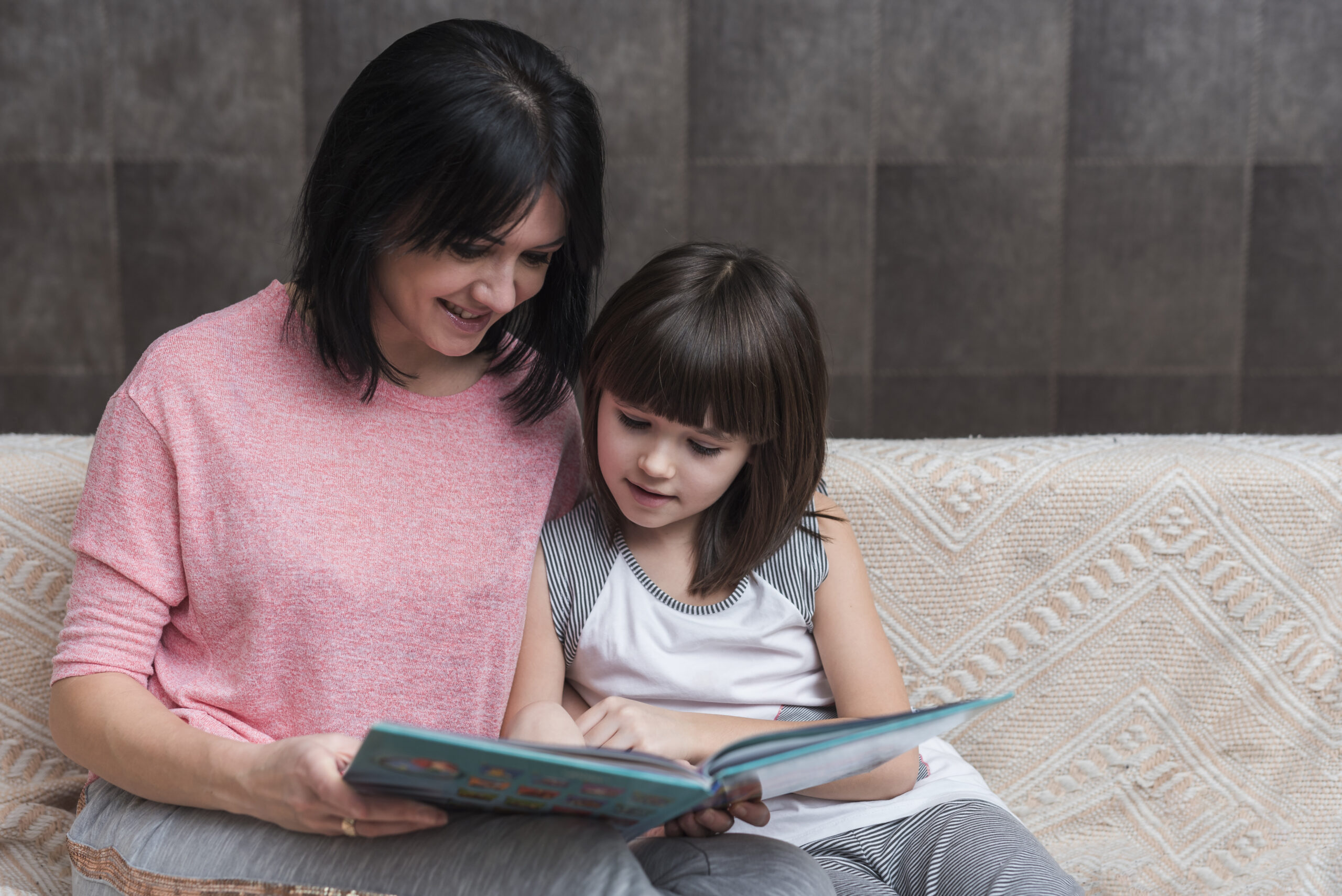 mother-little-daughter-reading-book-couch